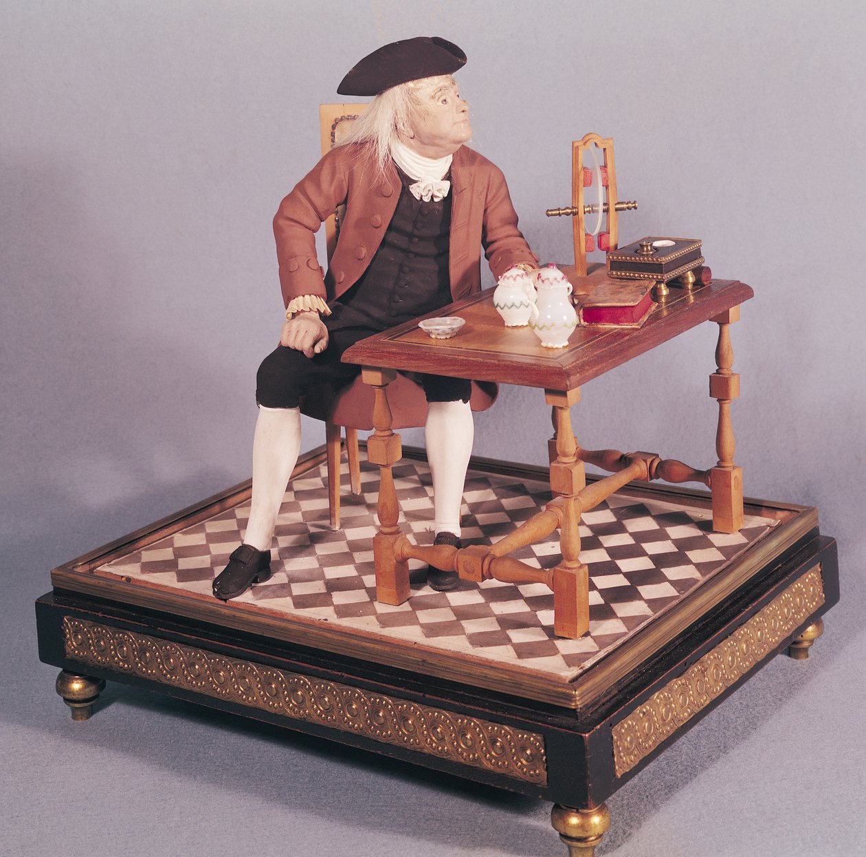Modell av Benjamin Franklin (1706-90) ved bordet hans, sent på 1700-tallet av French School
