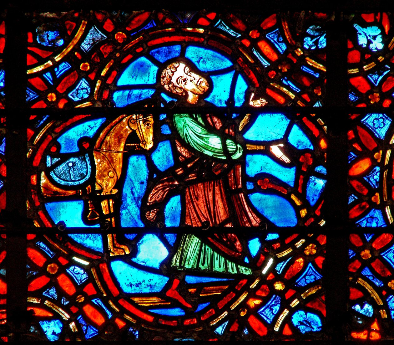 Vindu w12 som viser en scene i det barmhjertige samaritan-vinduet: samaritanen går av hesten sin av French School