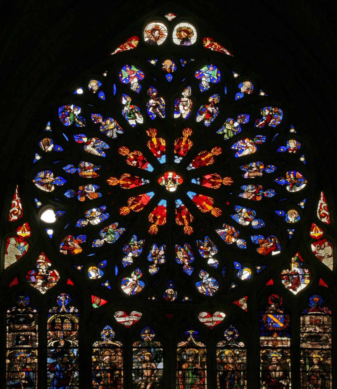 Vindu w135 som viser Gud, serafer, musikalske engler og ti av apostlene. lansettene nedenfor inneholder sene C16-figurer, skytshelgenene for de daværende kanonene: St James, St Christopher, St Charlemagn av French School