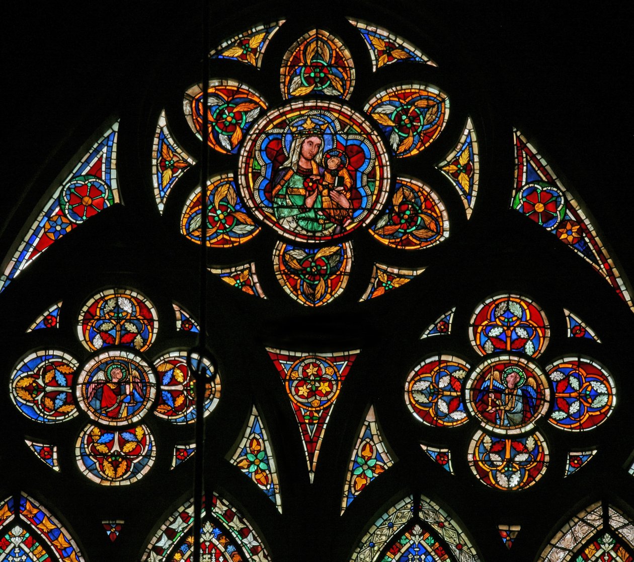 Vindu w207 som viser tracery-lysene med to engler og jomfruen og barnet av French School