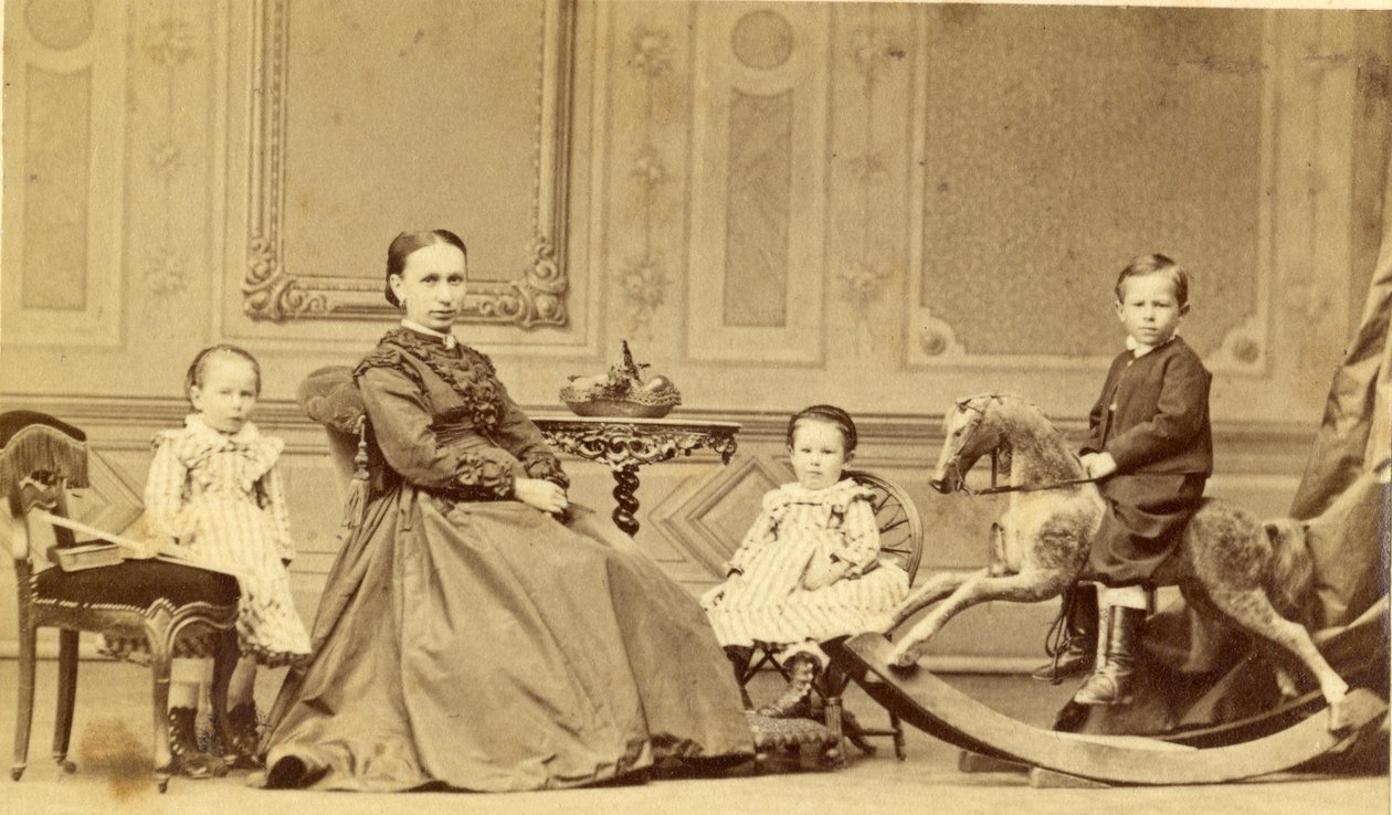 Ung gutt på gyngehest omgitt av familien sin, 1860-tallet (albumintrykk) av Georg Friedrich Brandseph