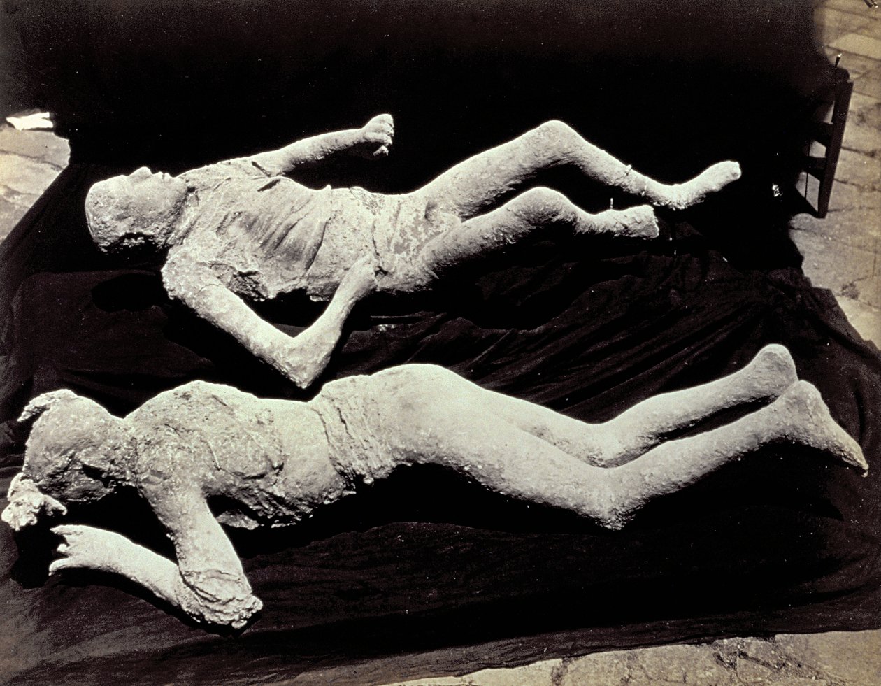 To avstøpninger av menneskelige figurer fra utgravningene i Pompeii. Utstillingene ble plassert på svart tøy for å fotografere dem av Giorgio Sommer