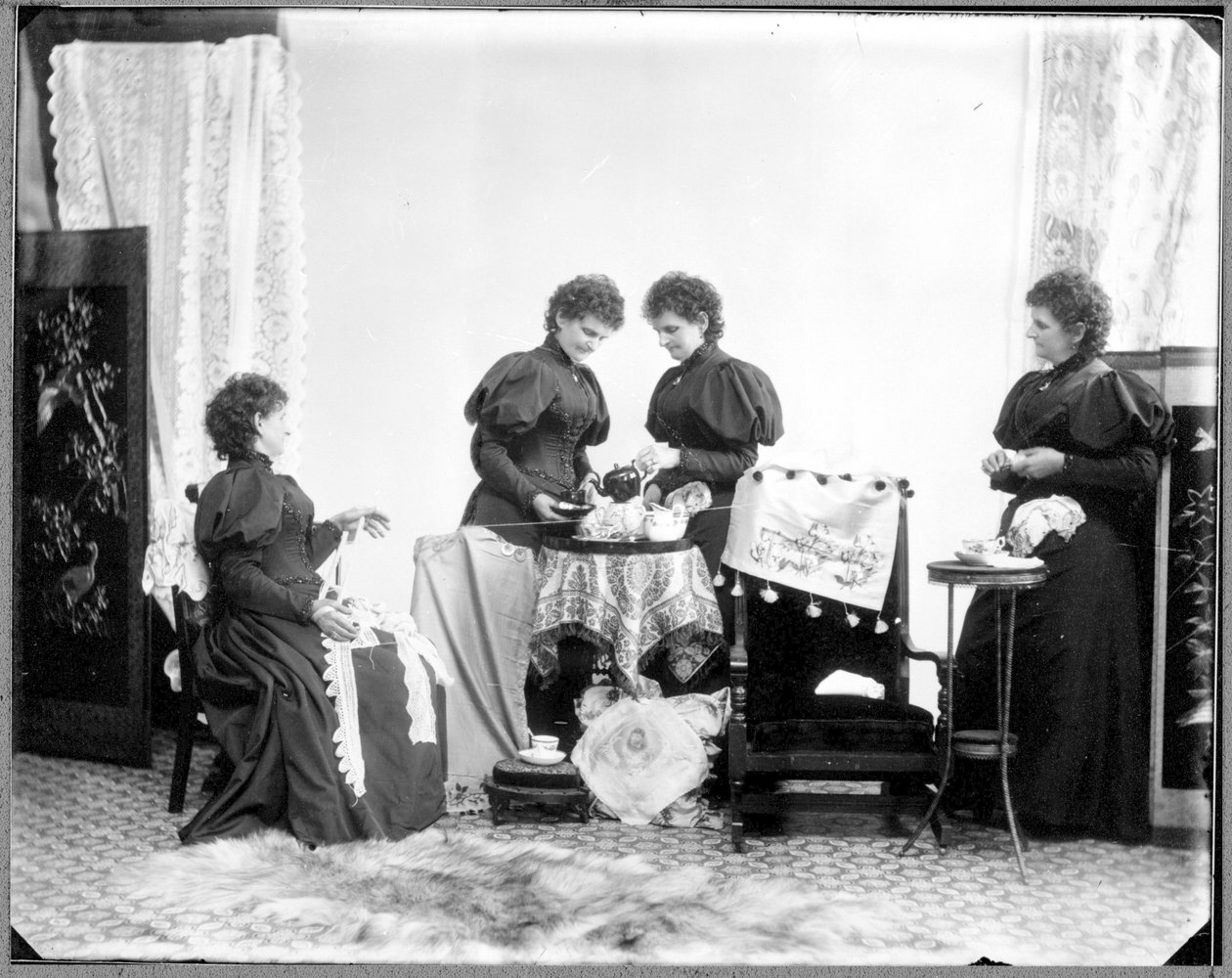 Multieksponering av Hannah Maynard - to som drikker te, en holder et nøste med bomull, en tar den opp til en ball, ca. 1895 (bw-bilde) av Hannah Maynard