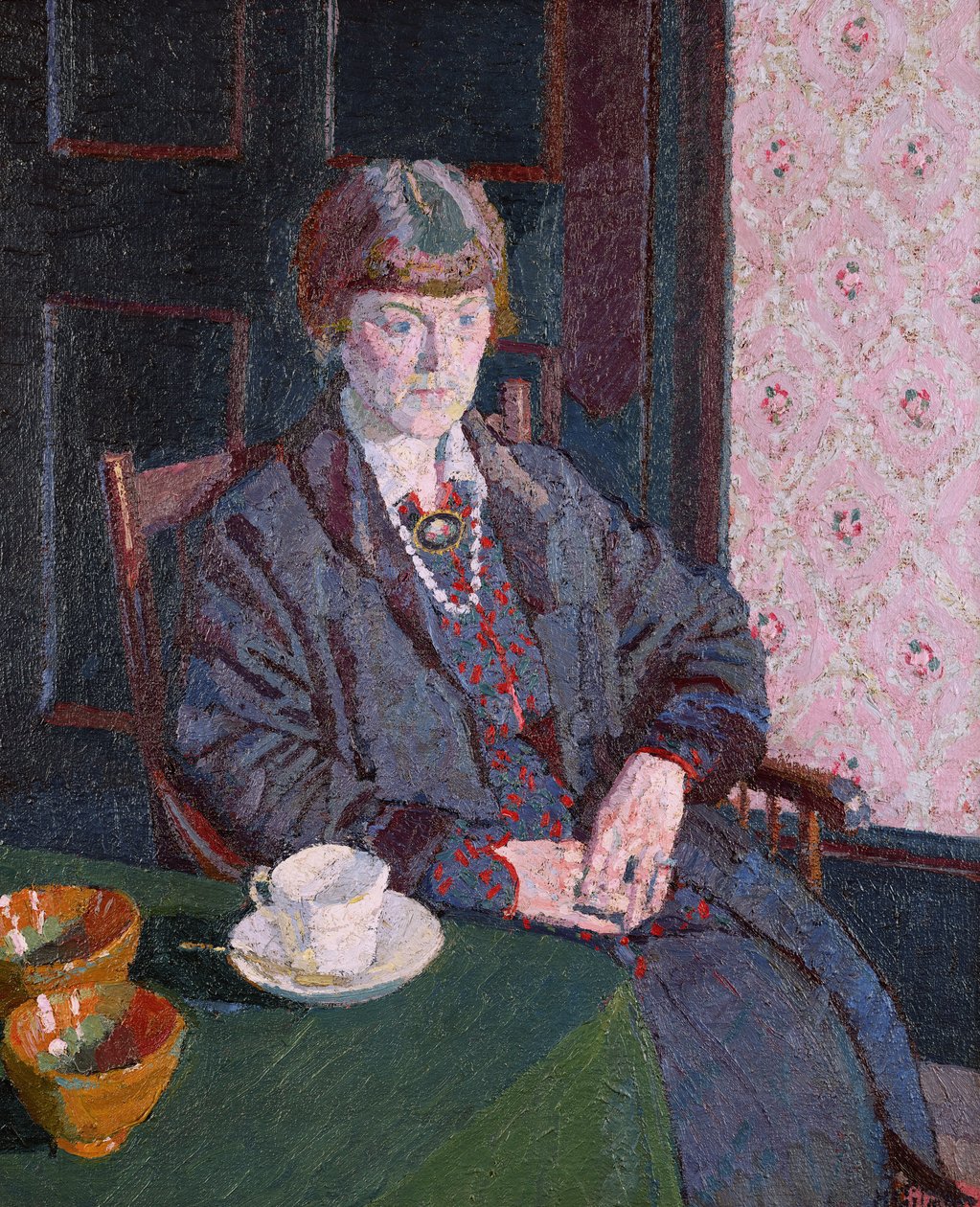 Kvinne sitter ved et bord av Harold Gilman