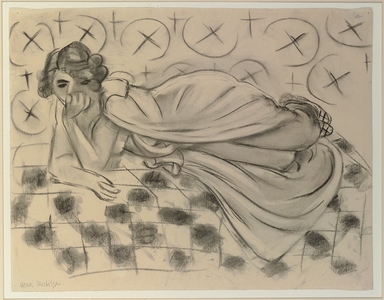 Drapert figur liggende på en svart rutete sofa av Henri Matisse