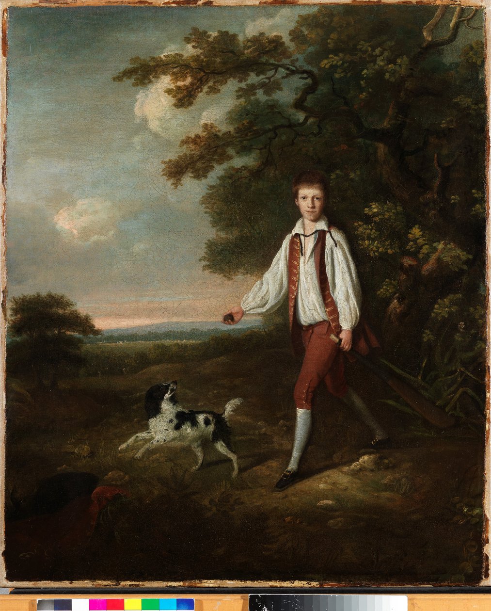 Portrett av en ungdom som holder et cricketballtre og ball med kjæledyret hans svart og hvite springer spaniel i en lysning ved et skogkledd landskap av Hugh Barron