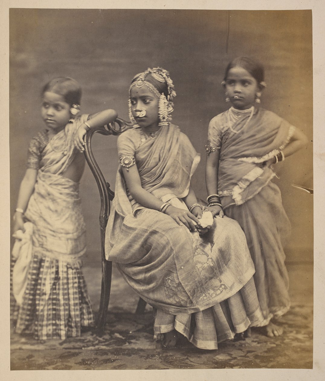 Group of children from Madras, showing mode of wearing jewellery, c.1870 (sepia photo)   1350996   no       norwegian Successfully Translated  Original: Le Drac Translat: Le Drac 1401637 no norwegian Successfully Translated Original: Lumber Yard Translat:  av Indian photographer