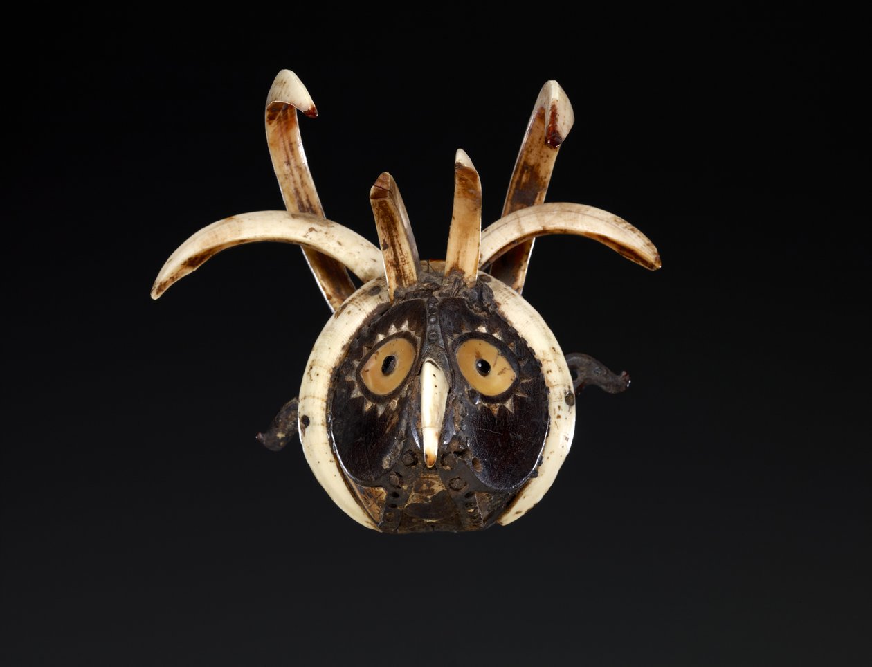 Munnmaske som sannsynligvis viser hodet til en hane (tre, villsvinstønner, muslingskall, perlemor, bøffelhorn, harpiksholdig materiale og pigment) av Indonesian School
