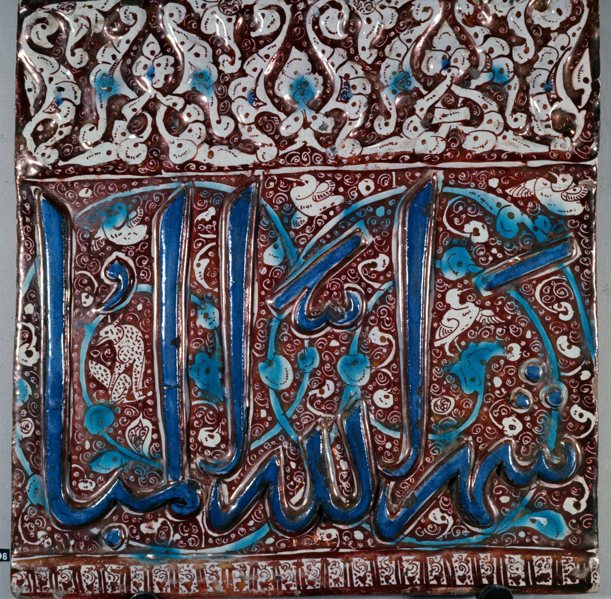 Islamsk kunst: veggkeramiske fliser emalje type "" lajvardina"" (lapis-lazuli) med inskripsjonen "" The month of God Beni""" fra Kashan, Iran. 1200-tallet. Dim. 36x36 cm arkeologisk museum i Teheran, Iran av Islamic School