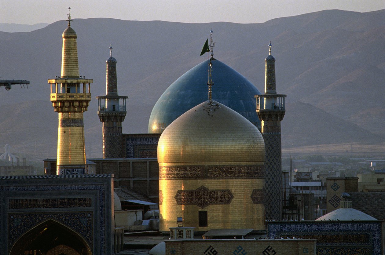 Helgullkuppelen og minareten til helligdommen til Imam Reza, den åttende sjia-imamen, med Timurid Gowhar Shad-moskeen bak av Islamic School