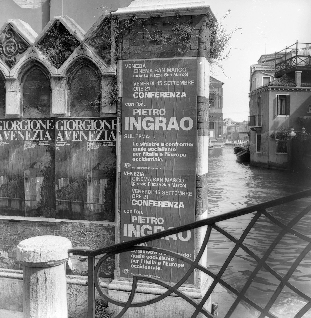 Utsikt over en kanal i Venezia med plakater som reklamerer for en Giorgione-utstilling og et politisk manifest i forgrunnen av Italian Photographer