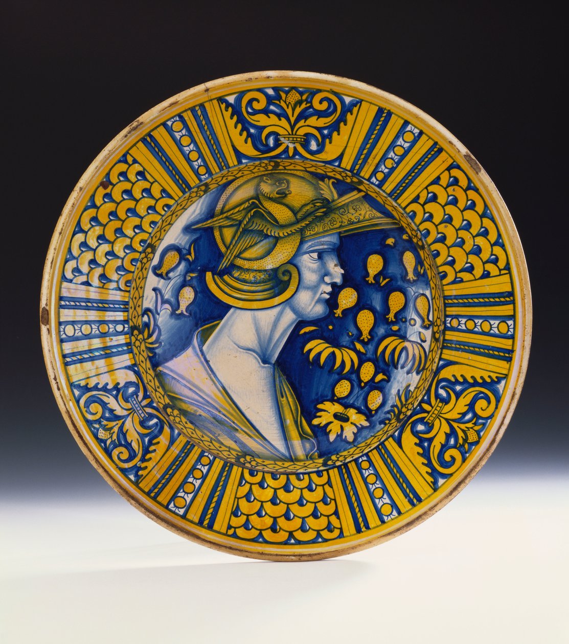 En Deruta-lustret portrettskål malt i blått og glanset i gult som viser en kriger i en hjelm med en bevinget griffin, ca. 1525 av Italian School