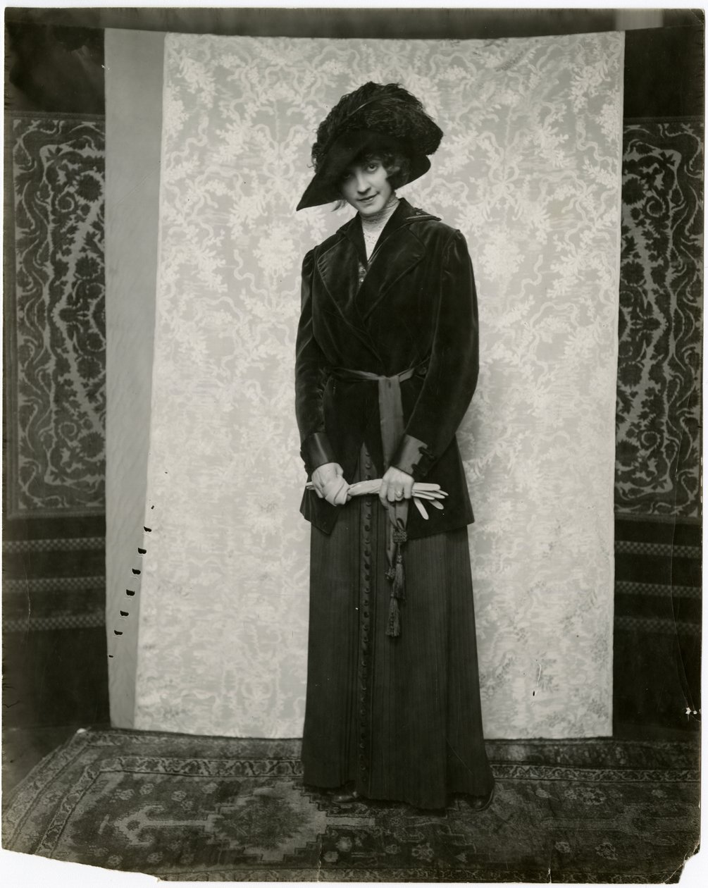 Rød fløyelsdress med plissert trekkskjørt, Arnold & Constable, ca. 1905-18 (foto av gelatinsølv) av Jessie Tarbox Beals