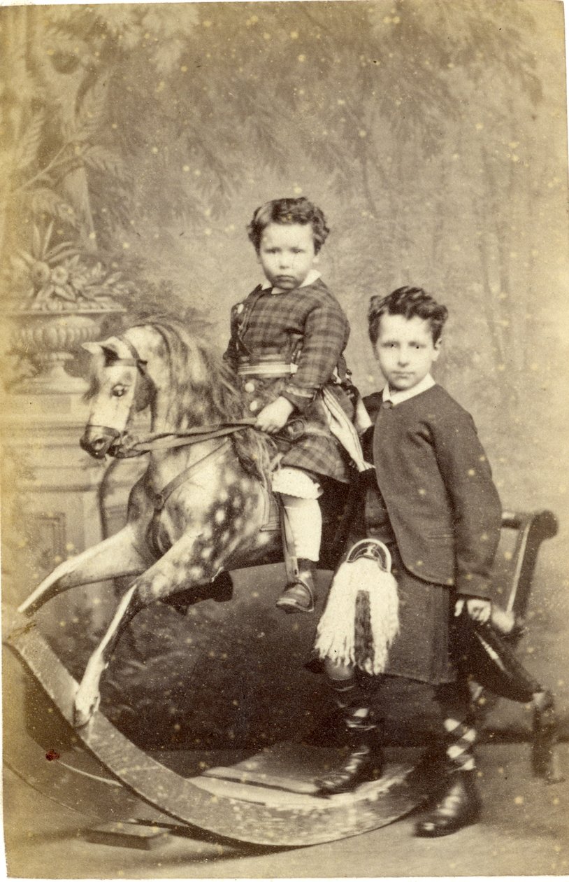 Ung jente på gyngehest med ung gutt i kilt stående, 1860-tallet (albumintrykk) av John Horsburgh