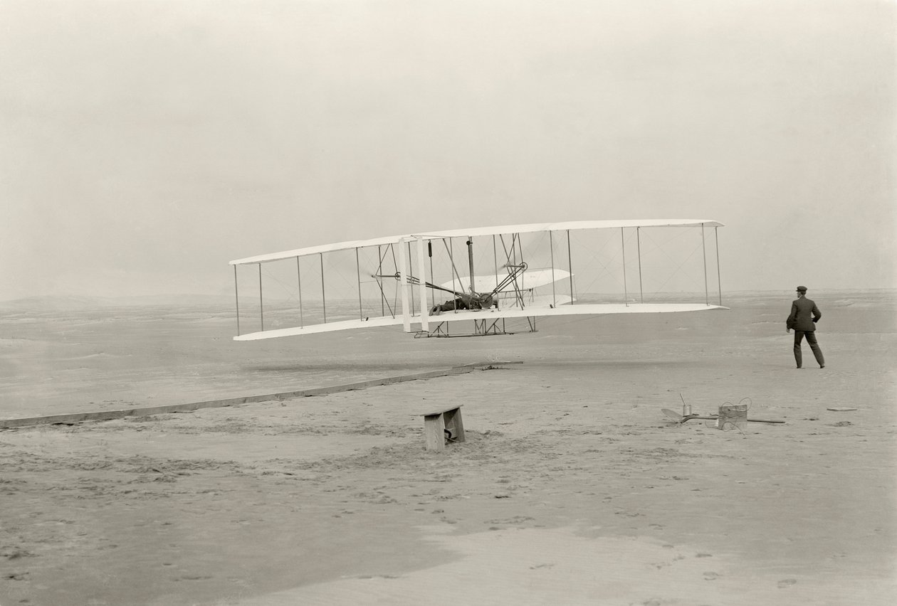Wright Flyer I gjør sin første flytur på 120 fot på 12 sekunder, i Kitty Hawk, North Carolina av John T. Daniels
