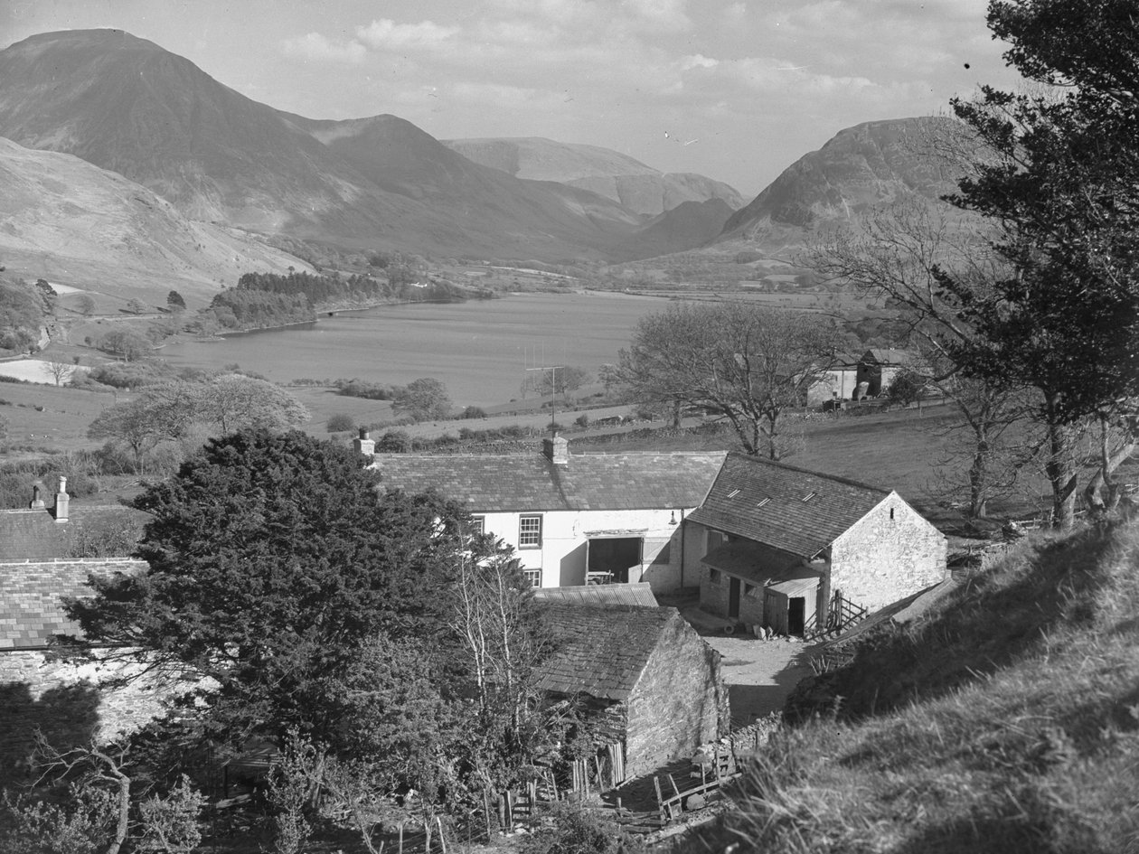 Utsikt over det som ser ut til å være en gård i forgrunnen og en innsjø og fjell i bakgrunnen av Joseph Hardman