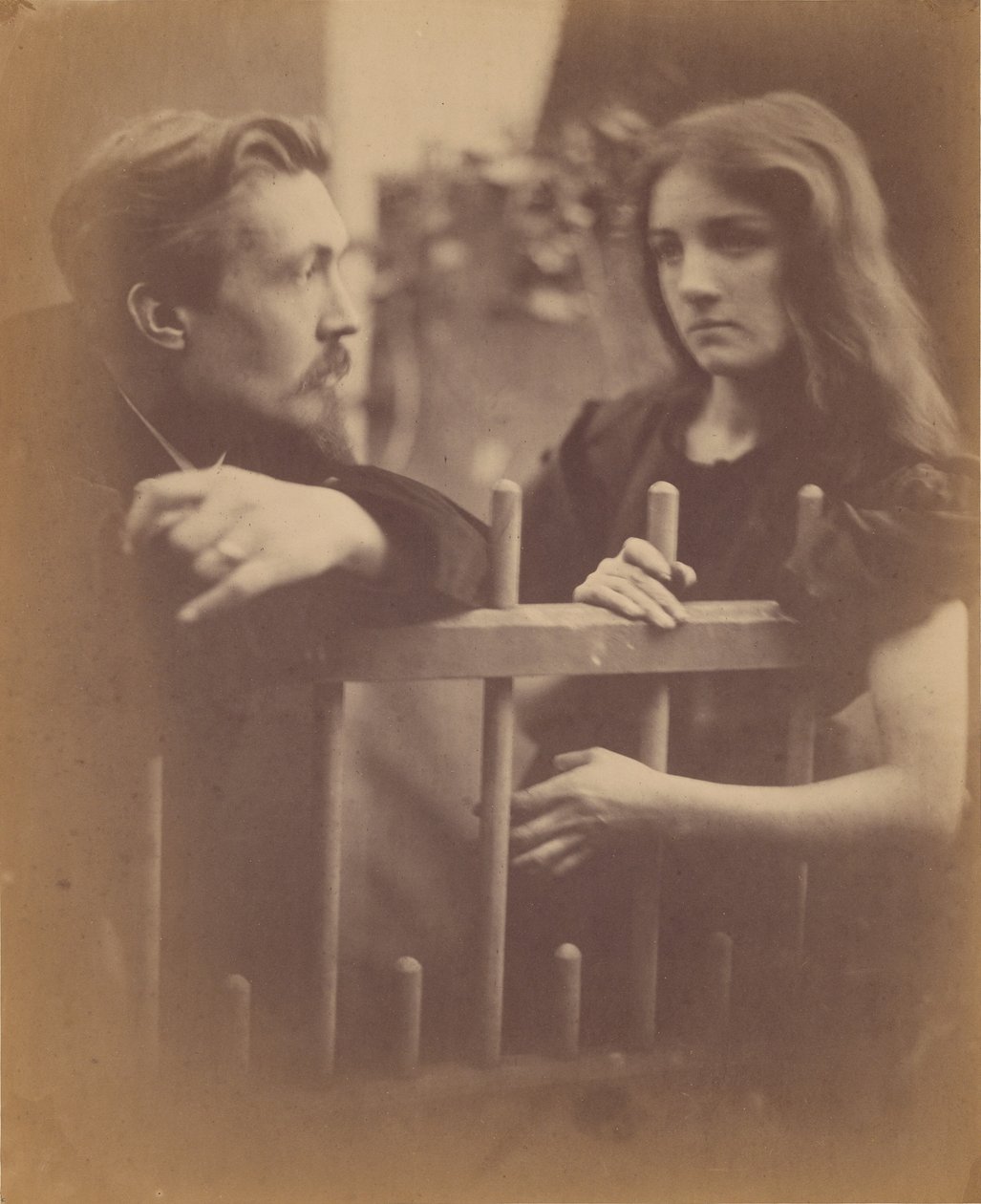 [Ung mann og ung kvinne lent mot et stakittgjerde] av Julia Margaret Cameron