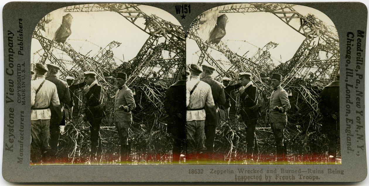Horisontalt sepia -stereokort som viser en gruppe uniformerte menn som undersøker vraket av en zeppelin. Keystone Stereograf nummer 18632. Tittelen lyder av Keystone View Company