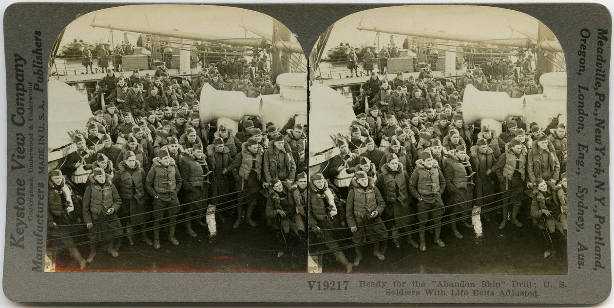 Horisontalt, sepia -stereokort som viser uniformerte amerikanske soldater iført redningsvest som står og sitter på dekket på et skip. Keystone stereografnummer V19217. Tittelen lyder av Keystone View Company