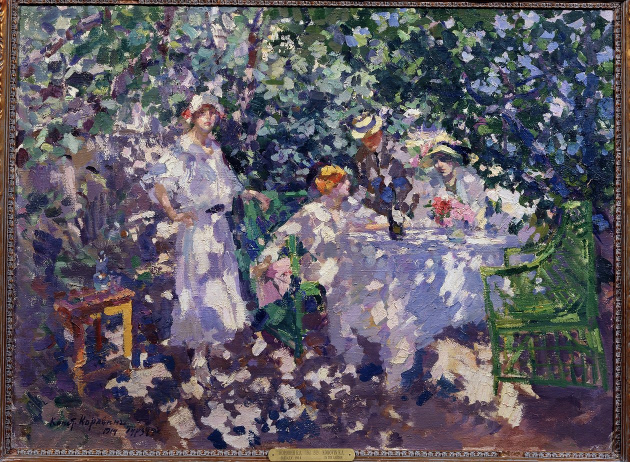 I hagen (I hagen). Et bord dekket i lundene, om sommeren, drar tre unge kvinner og en mann, sittende, iført stråhatter, nytte av skyggen. Maleri av Konstantin Alexeyevich Korovin (Constantin Korovin) (1861-1939), olje av Konstantin Alekseevich Korovin