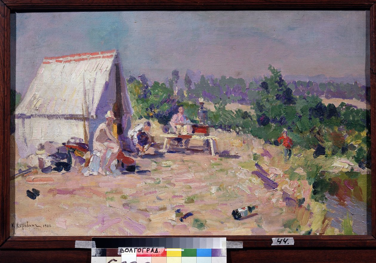 En piknik (piknik). (Piknik). Scene av familielivet, ved kanten av en elv, er et telt og noen sammenleggbare møbler installert i solen, for en utendørs lunsj og en dag med avslapning. Noe søppel strødd ut i bakken. Maling av av Konstantin Alekseevich Korovin