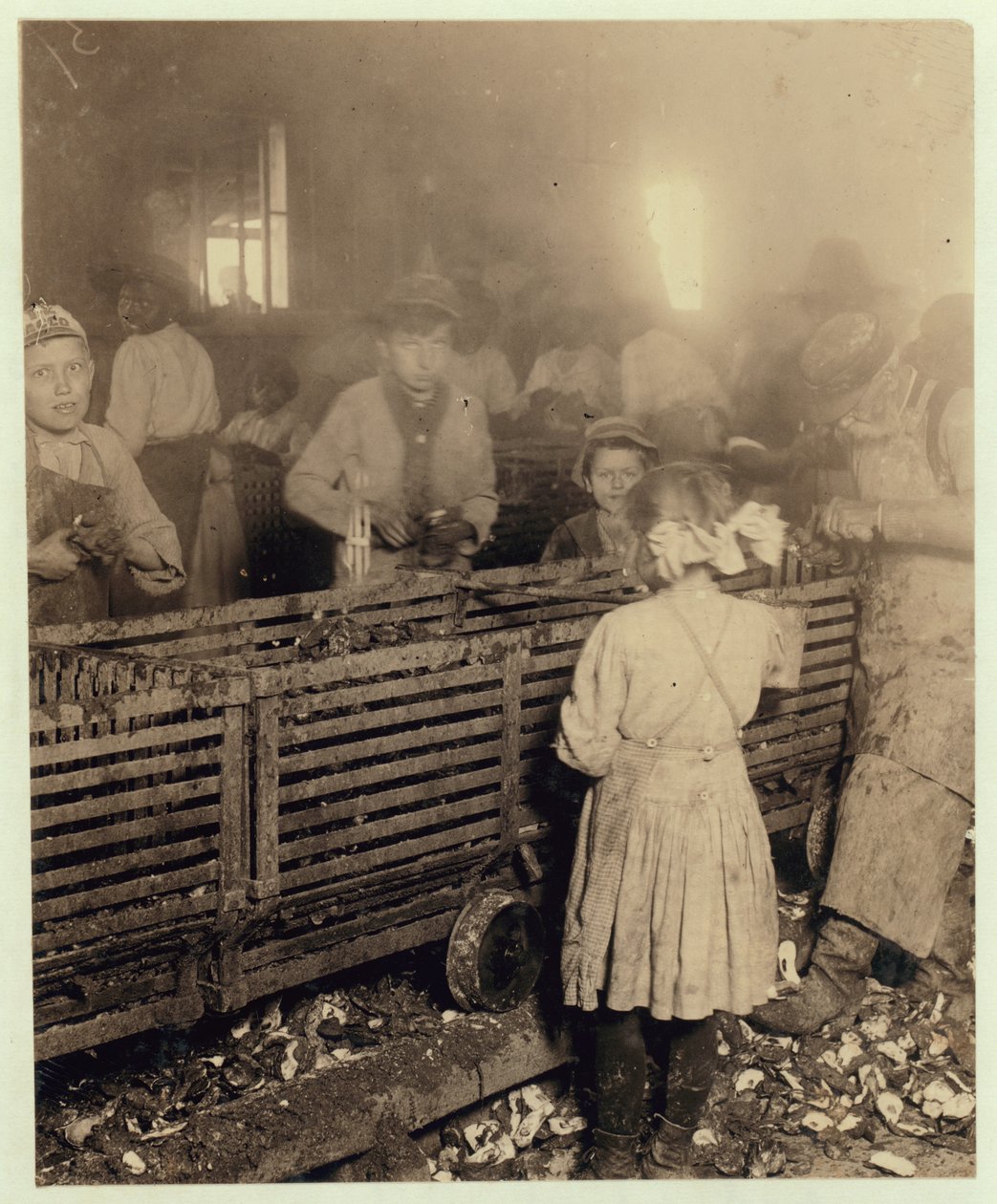 Factory of Lowden Canning Company, Bluffton, South Carolina som viser en 7 år gammel jente som kaster 3 potter med østers om dagen med sin 6 år gamle bror og en 11 år gammel gutt som gjør 6 potter, 1913 (bw p av Lewis Wickes Hine