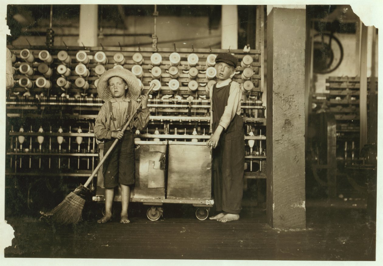 12 år gamle doffer Ronald Webb og 7 år gamle Frank Robinson, sønn av cardroom-sjefen, som feier og fjerner (rydder hele spoler) ved Roanoke Cotton Mills, Virginia, 1911 av Lewis Wickes Hine