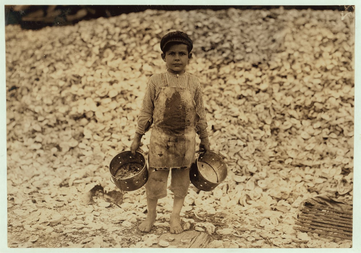 5 år gamle migrant rekeplukker Manuel foran en haug med østersskjell, jobber i et andre år i Dunbar, Lopez, Dukate Company, Biloxi, Mississippi, 1911 av Lewis Wickes Hine