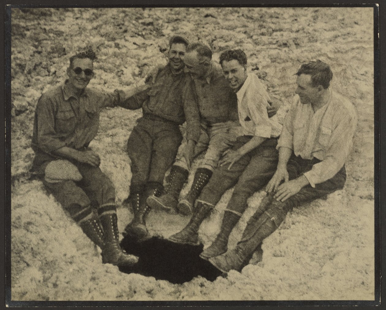 [Gruppebilde av personer sittende ved inngangen til en loddrett hule, San Jacinto Peak] av Louis Fleckenstein