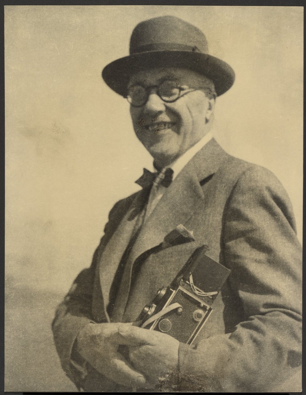 [Portrett av en mann med et kamera] av Louis Fleckenstein