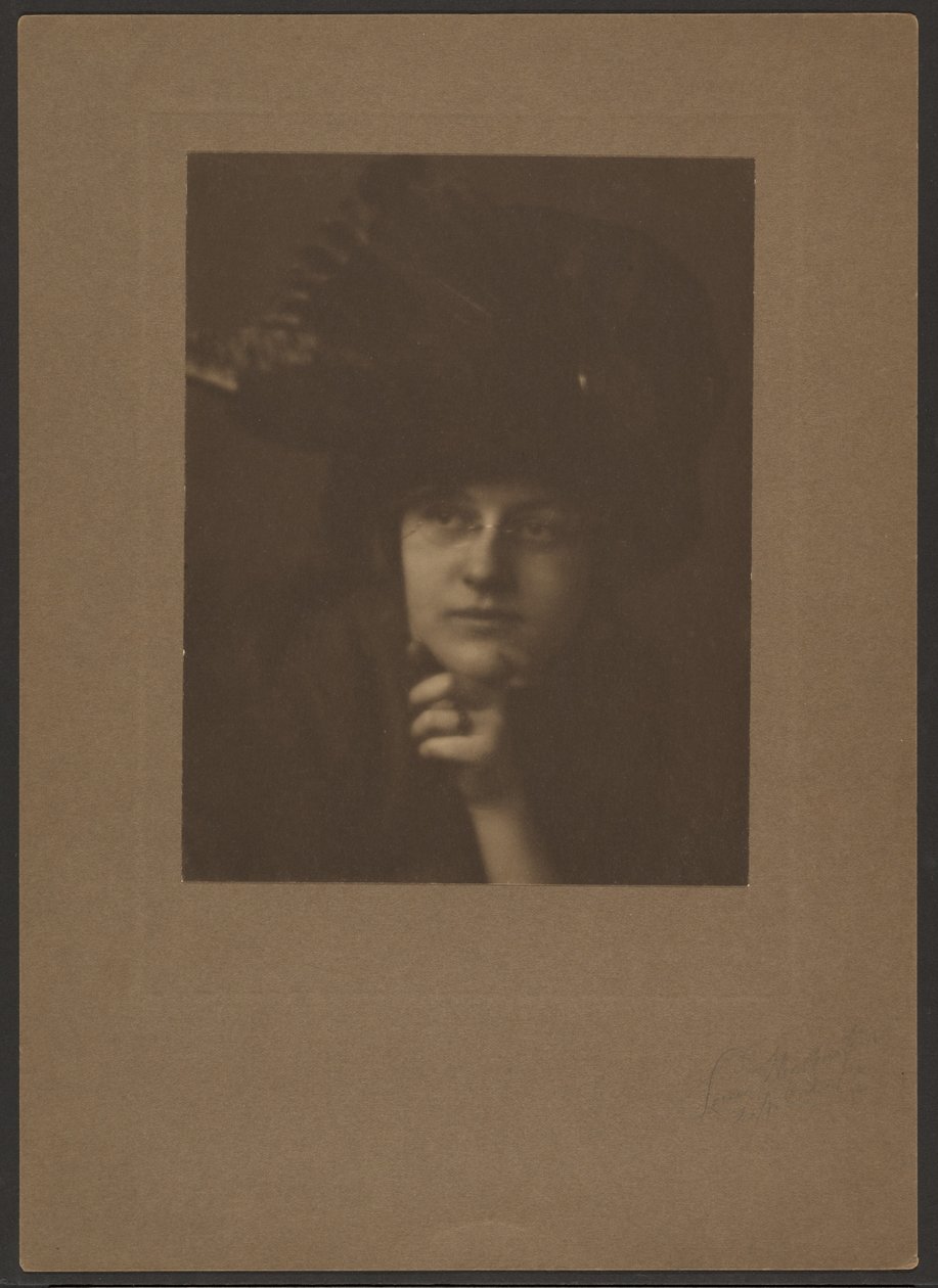 [Portrett av en kvinne med stor hatt og briller] av Louis Fleckenstein