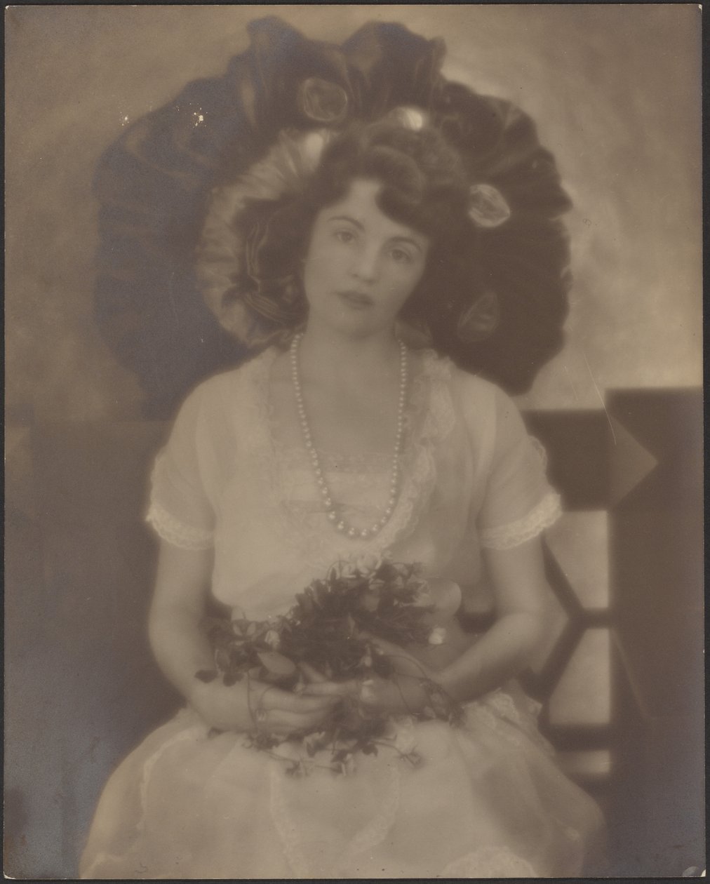 [Portrett av en ung kvinne med blomster i fanget] av Louis Fleckenstein