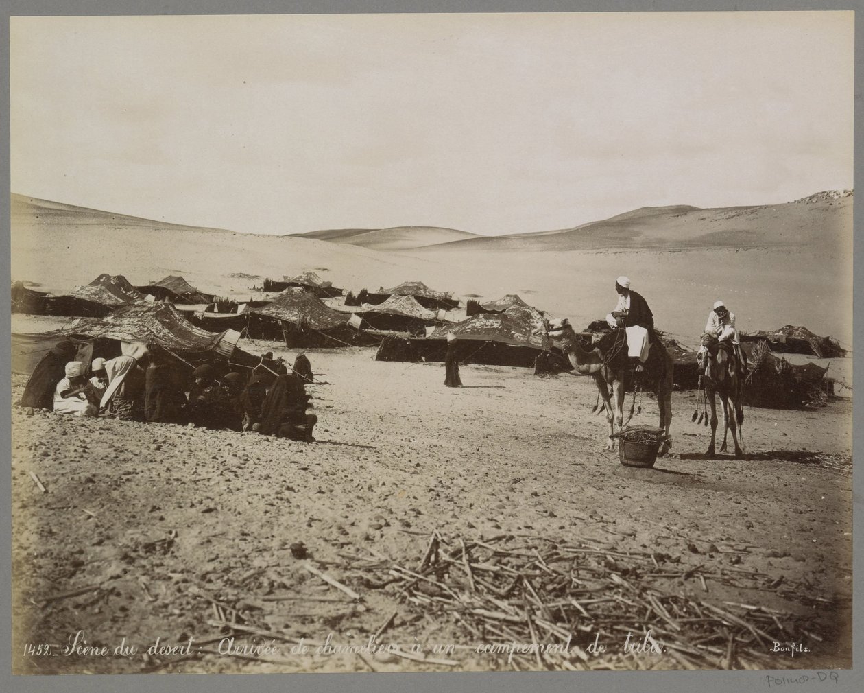 Leir med telt og kameler i (antagelig) Egypts ørken Scene du desert: Arrivée de chameliers à un campement de tribu. (tittel på objekt) av Maison Bonfils