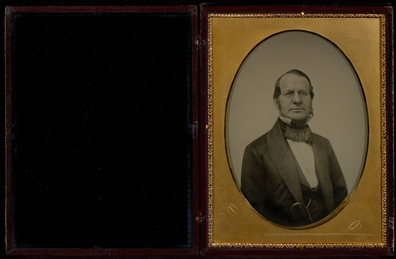 Portrett av en uidentifisert middelaldrende mann med kinnskjegg og briller med trådinnfatning av Mathew B. Brady