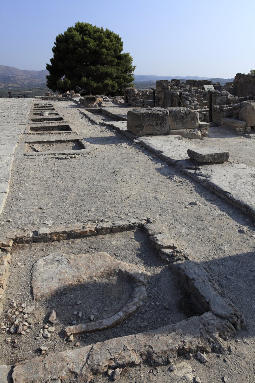 Det minoiske arkeologiske stedet Phaistos. Generell utsikt over vestfløyen helligdommer langs den sentrale domstolen fra nordfløyen. Det var to typer helligdom: "Bench shrine" og "Lutral Basin"". "" Benk Shrine"" var et lite og rektangulært rom med lavt gu av Minoan