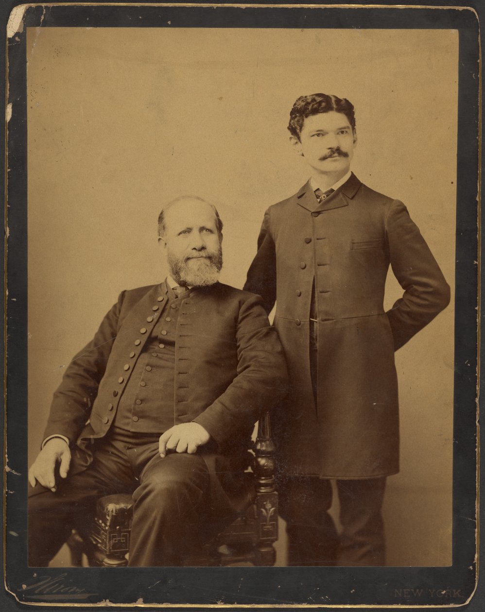 [Uidentifisert skjeggete sittende mann med uidentifisert stående mann med bart] av Napoleon Sarony