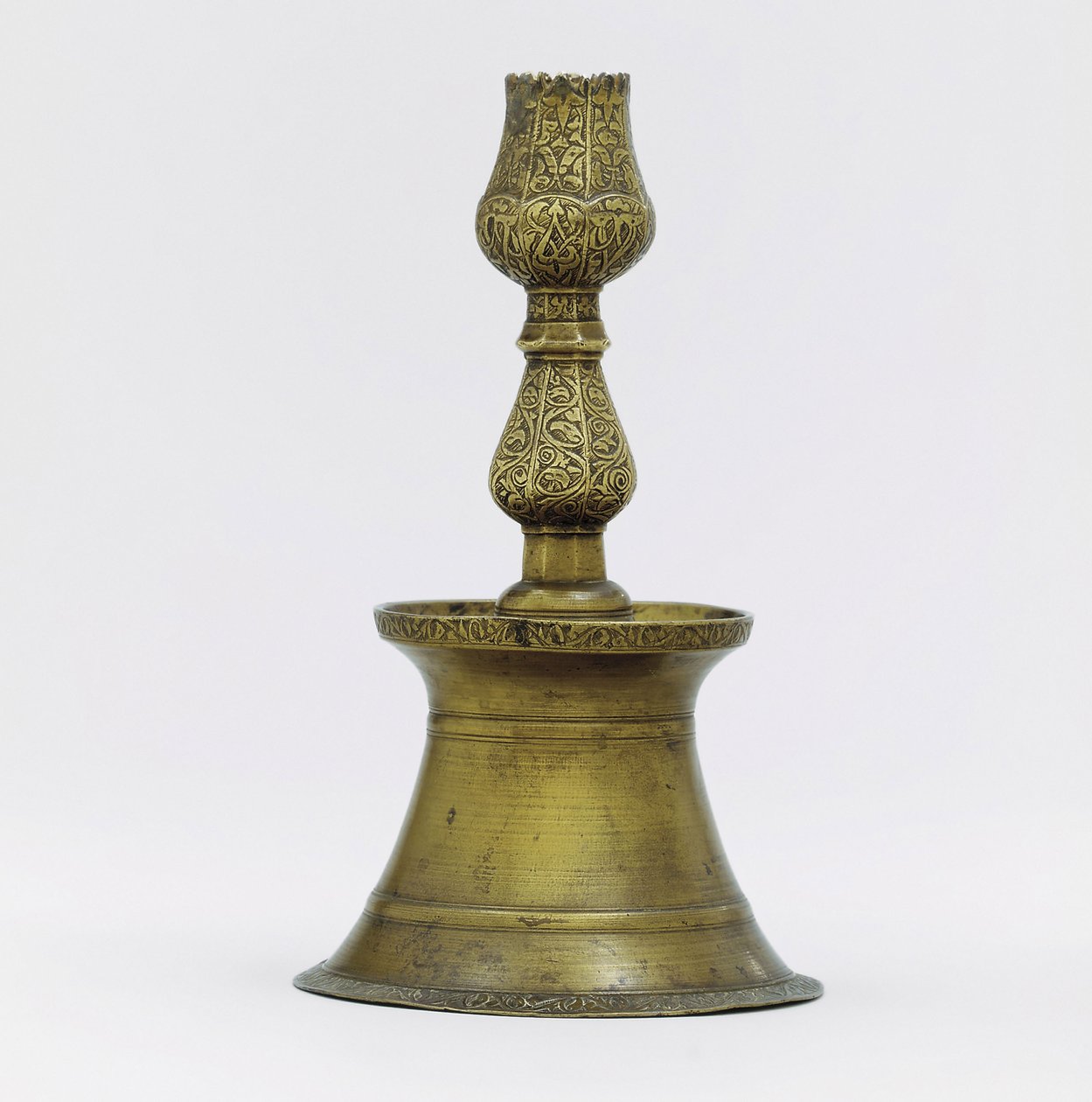 En ottomansk lysestake i messing, halsen med innskåret arabesk-dekor som stiger opp i form av en tulipan av Ottoman School