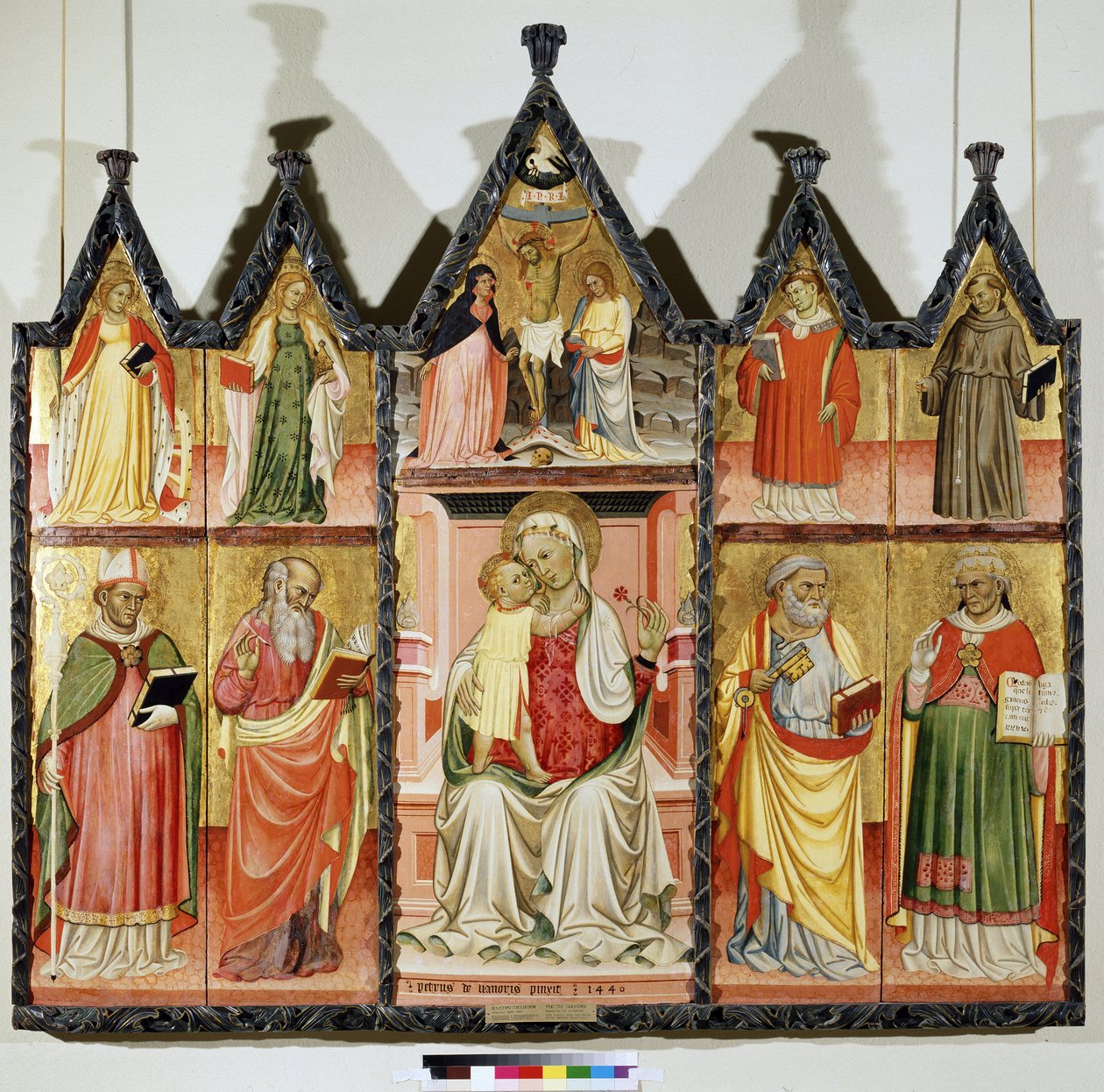 Polyptyk av jomfru og barn med hellige. Øverst til venstre: Den hellige Katarina av Alexandria og den hellige Maria Magdalena. I sentrum rundt Kristus på korset med inskripsjonen ""INRI"" (I.N.R.I.). Jomfru Maria og Johannes. Øverst til høyre: S av Pietro di Giovanni Lianori