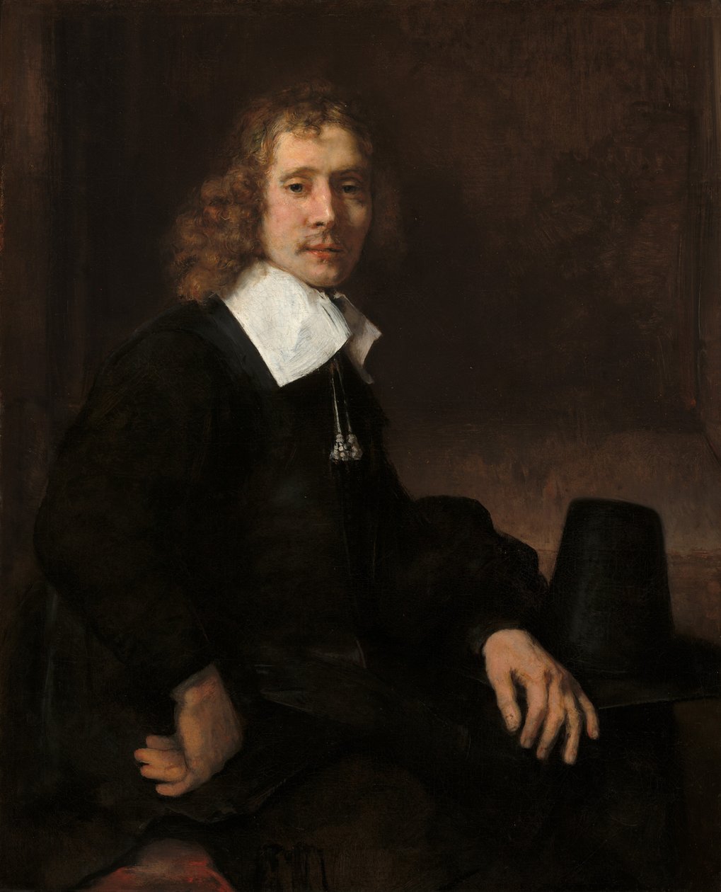 En ung mann som sitter ved et bord, muligens Govaert Flinck, ca. 1660. av Rembrandt van Rijn