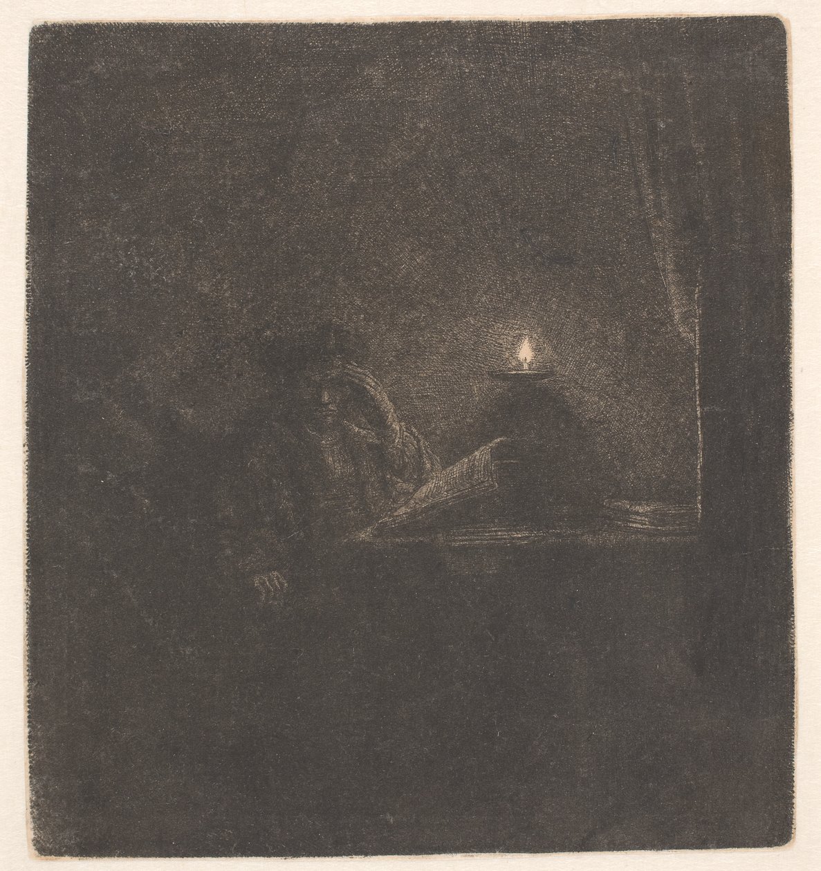 En student ved et bord i stearinlysets skinn av Rembrandt van Rijn
