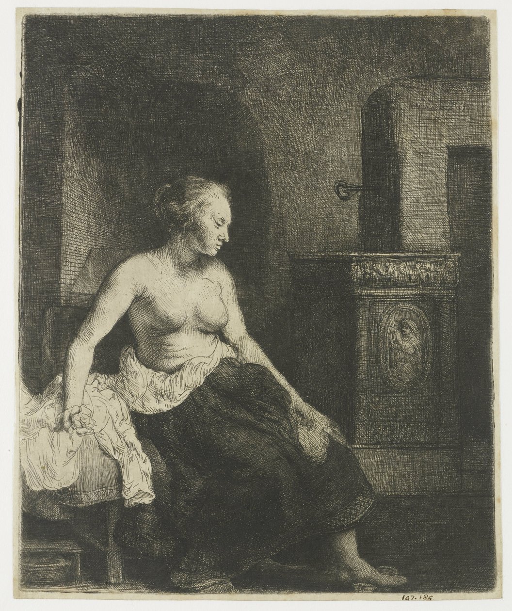 Kvinne som sitter halvkledd ved siden av en komfyr av Rembrandt van Rijn