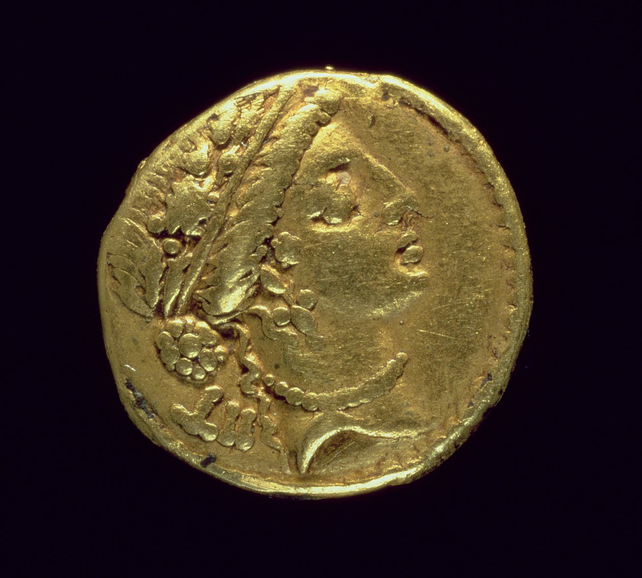 Aureus (forside) preget av Julius Caesar (110-44 f.Kr.) som viser et kvinnelig hode til høyre iført en eikekrans og diadem (gull) av Roman