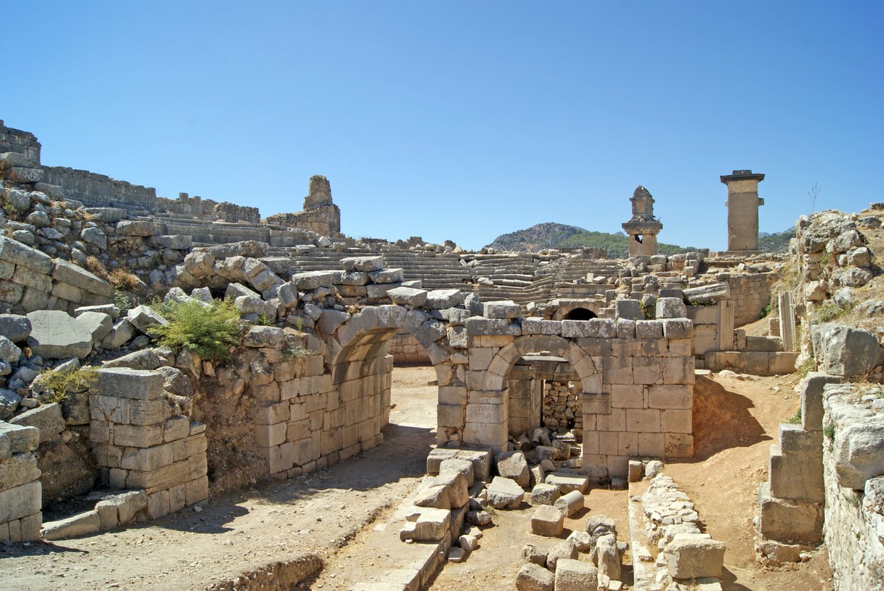 Utsikt gjennom den hvelvede inngangen til Xanthos-teatret inn i orkestergraven, og viser søyle og Harpy-grav, Xanthos, Tyrkia (bilde) av Roman