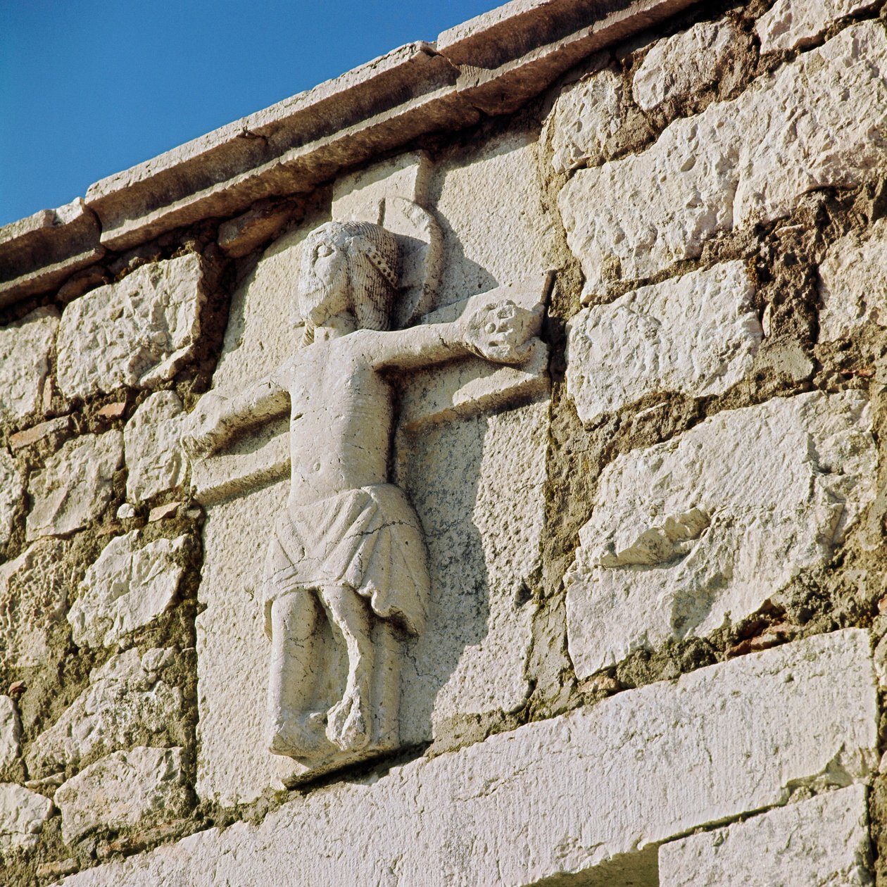 Kristus korsfester steinskulptur fra det 13. århundre. Portal til den romanske kirken San Bartolomeo, Campobasso Italia av Romanesque
