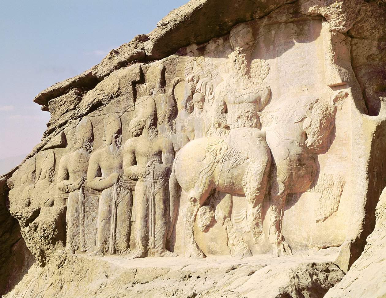 Steinrelieff som viser Shapur I (241-272 e.Kr.) og hans familie med heraldiske emblemer på hattene (bilde) av Sasanian