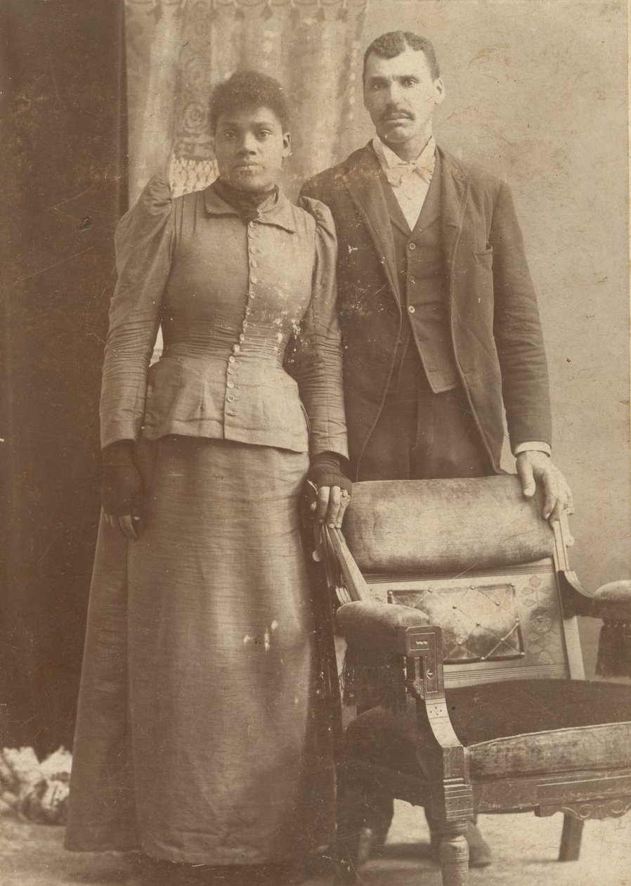 Fotografi av et afroamerikansk par som står bak en stol, ca. 1890. av Schmitz Studio
