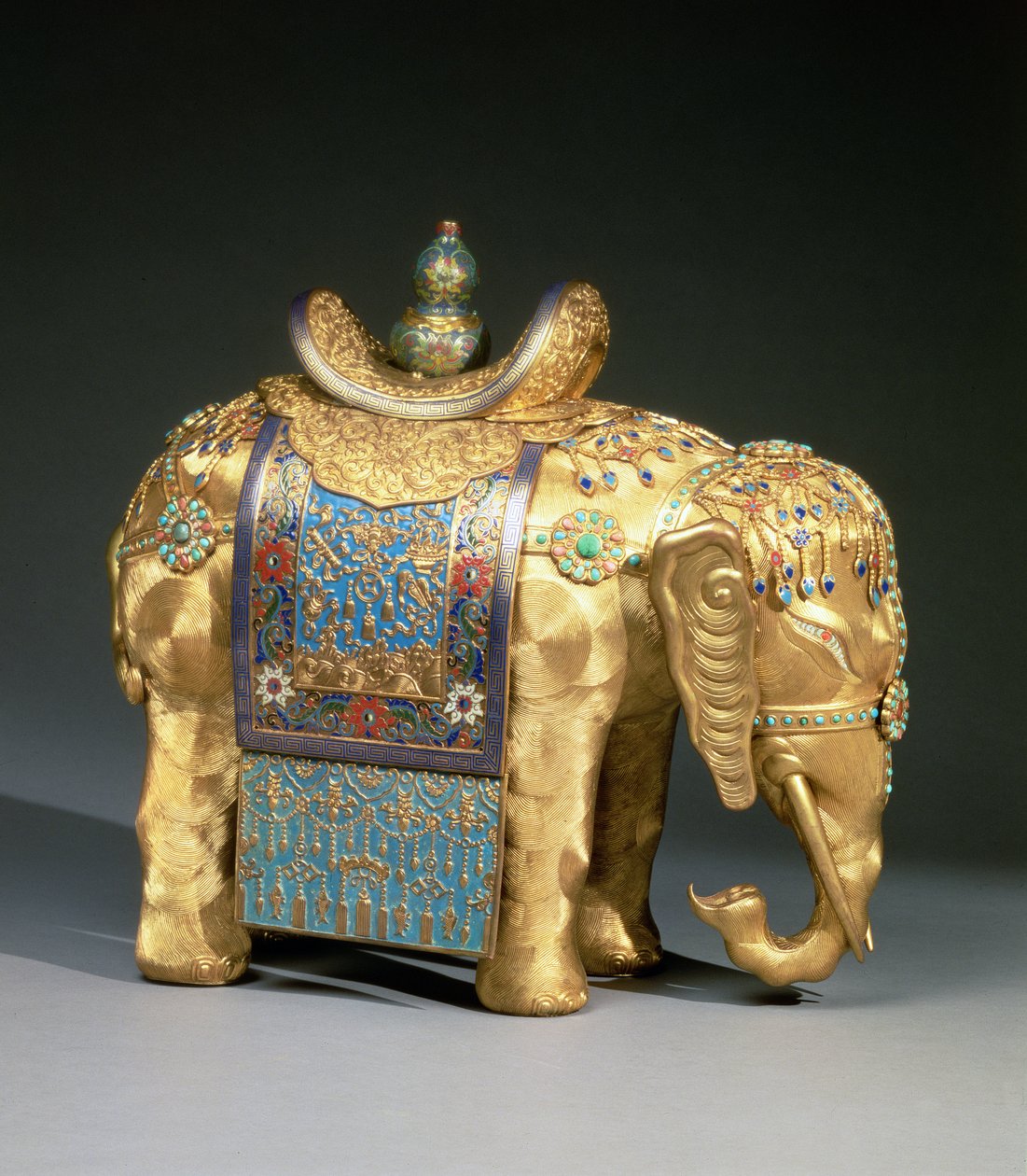 Figur av en elefant, med emaljefester og koraller og turkise cabochons, sadelduk dekorert med buddhistiske emblemer, Chien Lung Period, ca. 1780 (forgylt bronse, emalje, koraller og turkis) av School Chinese