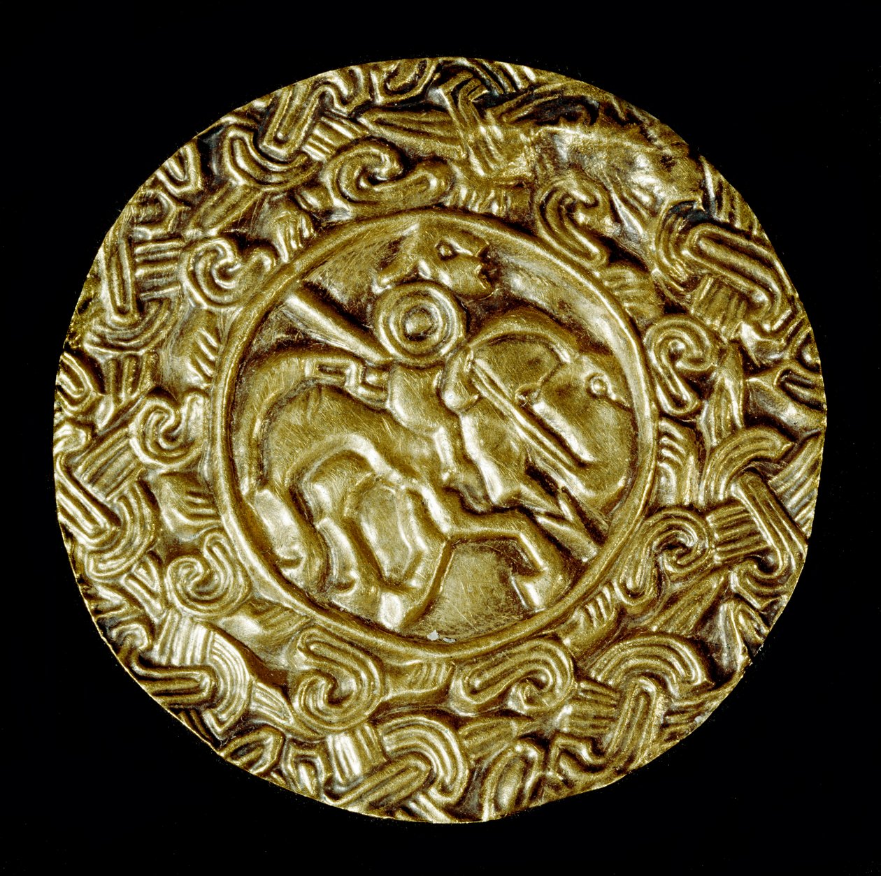 Arkeologi i middelalderen (middelalderen). Barbarkunst fra Lombardia: gullskive. I sentrum står en helgen til hest med spyd og rundt dyremotiver. Lombard kunst, rundt 600. Dim: 47 cm Italia, Cividale del Friuli, Arkeologisk museum av School Lombard