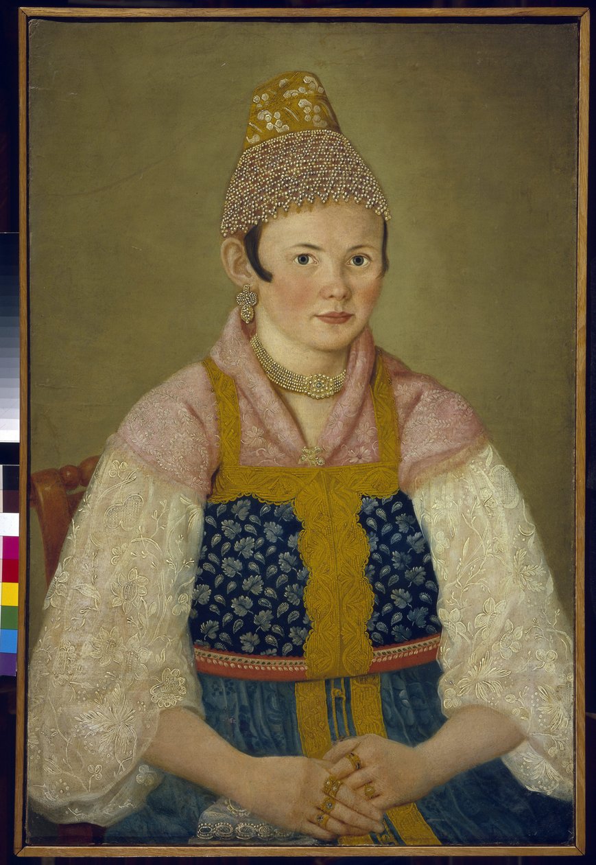 Portrett av en kjøpmanns kone, hodeplagg av den tradisjonelle kokoshnik. (Portrett av en handelskvinne i Kokoshnik Kabluchok). Hun har også på seg den tradisjonelle russiske kjolen (sarafane) dekorert med broderi, med en bluse med blondermer, hodeplagget h av School Russian