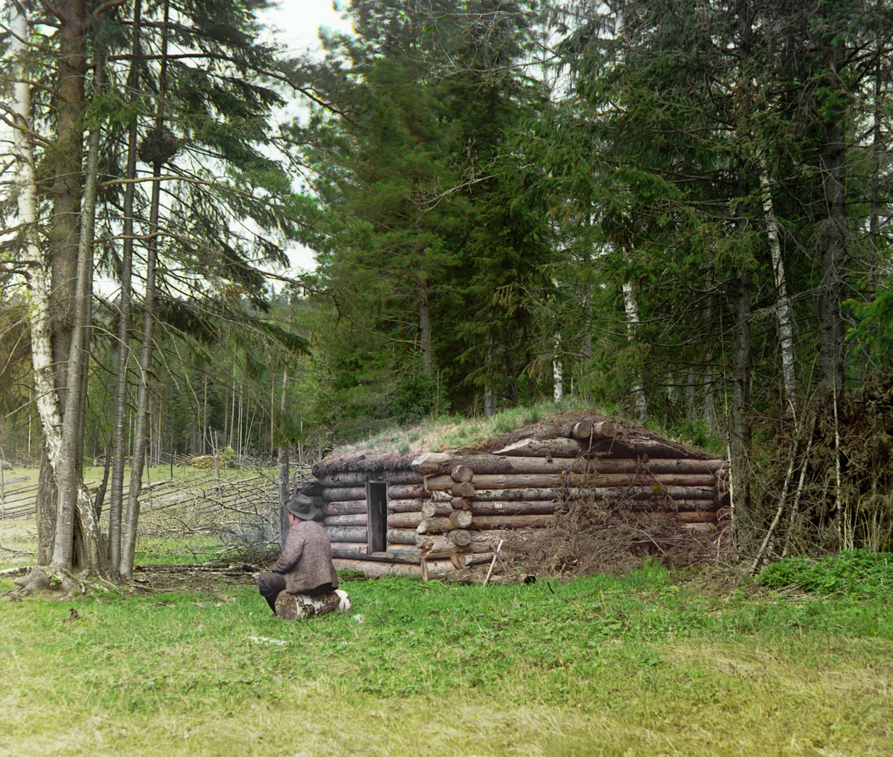 En mann foran en hytte for vedhoggere og kuria (kullbrenning) i skogen, det russiske imperiet, mellom 1905 og 1915 av Sergey Prokudin Gorsky